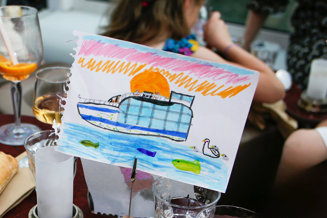 Souvenir d'enfant avec illustration de bateau pendant un diner croisière joyeux sur la Seine | Paris en Scène