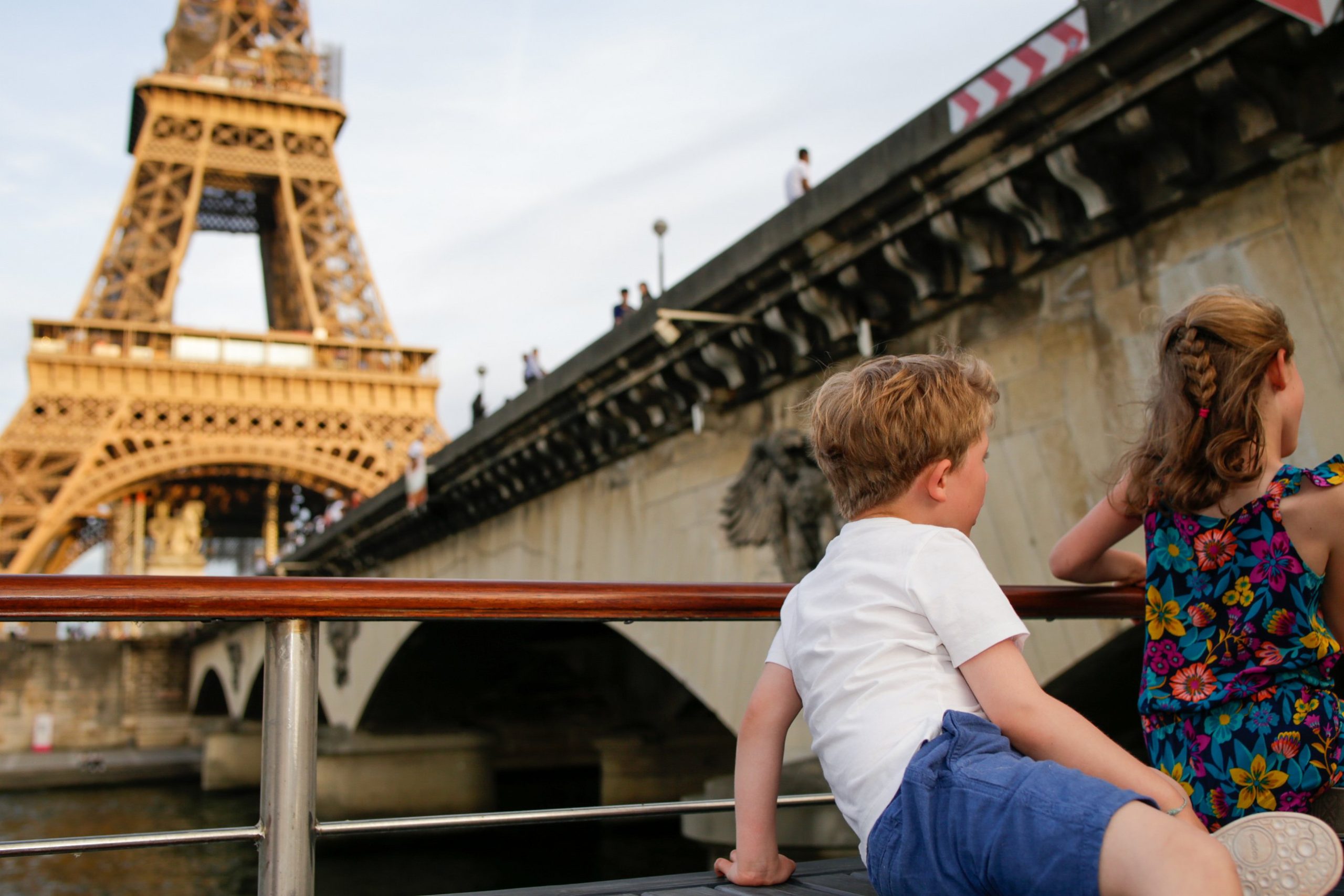 Enfants profitant d'un dîner croisière sur la Seine à Paris, avec vue sur la Tour Eiffel emblématique, offrant une expérience inoubliable en famille | Paris en Scène