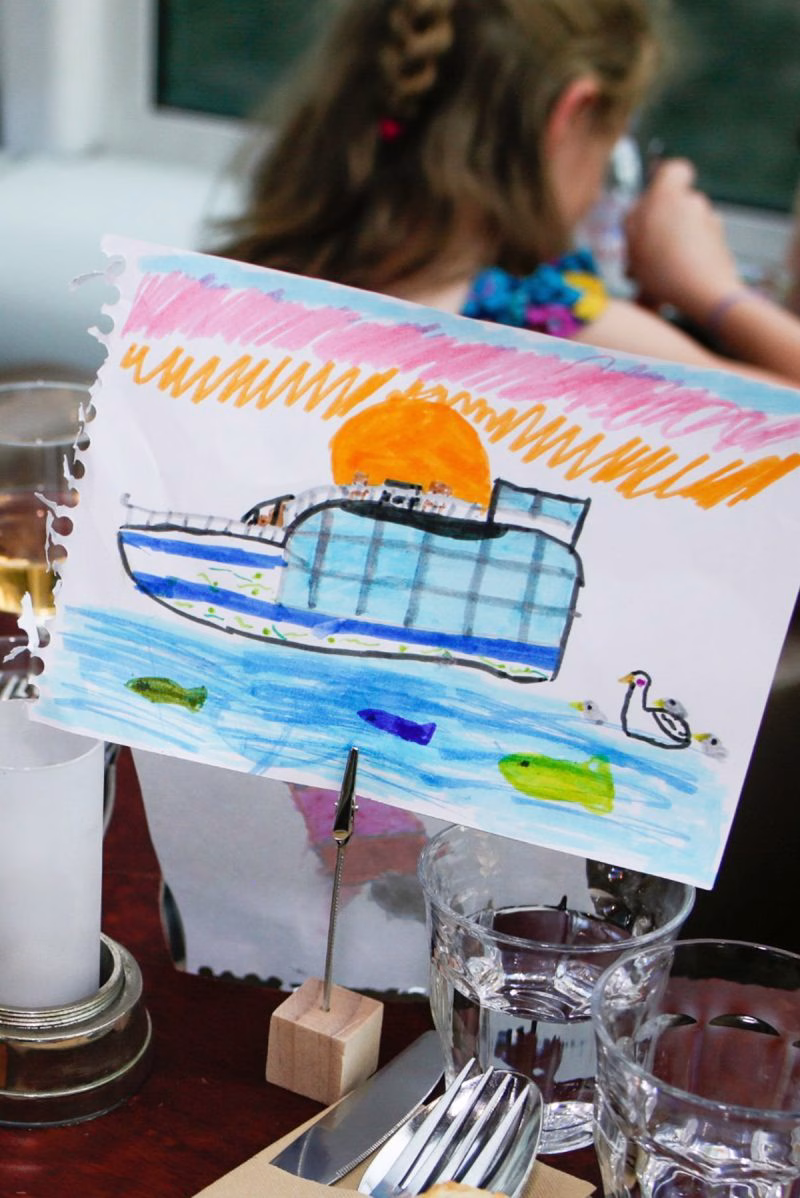 Moment famille avec dessin de bateau durant un diner croisière mémorable sur la Seine | Paris en Scène