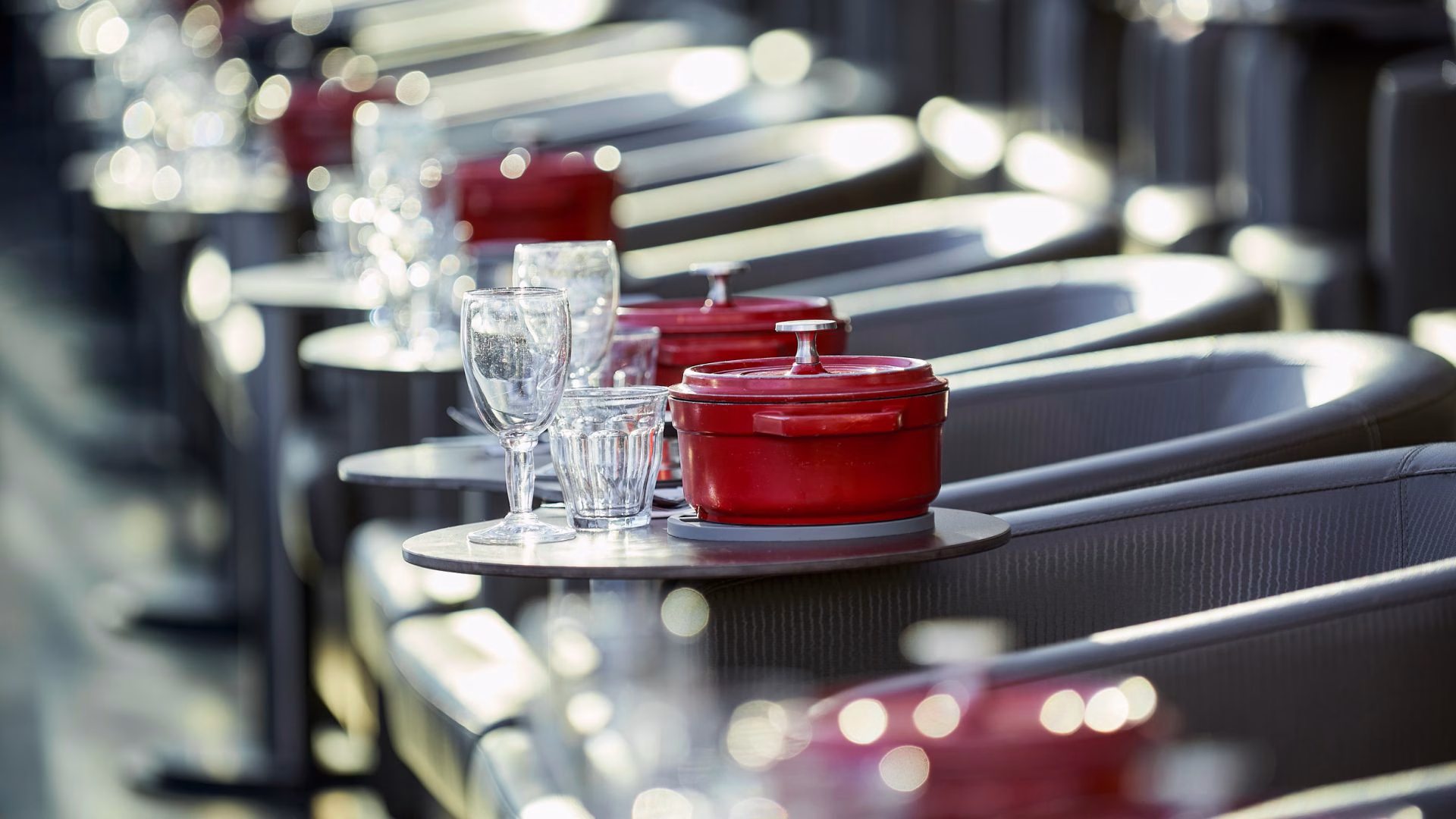 Cocotte rouge et verres cristal avec effet bokeh lors d'un diner croisière élégant sur la Seine | Paris en Scène