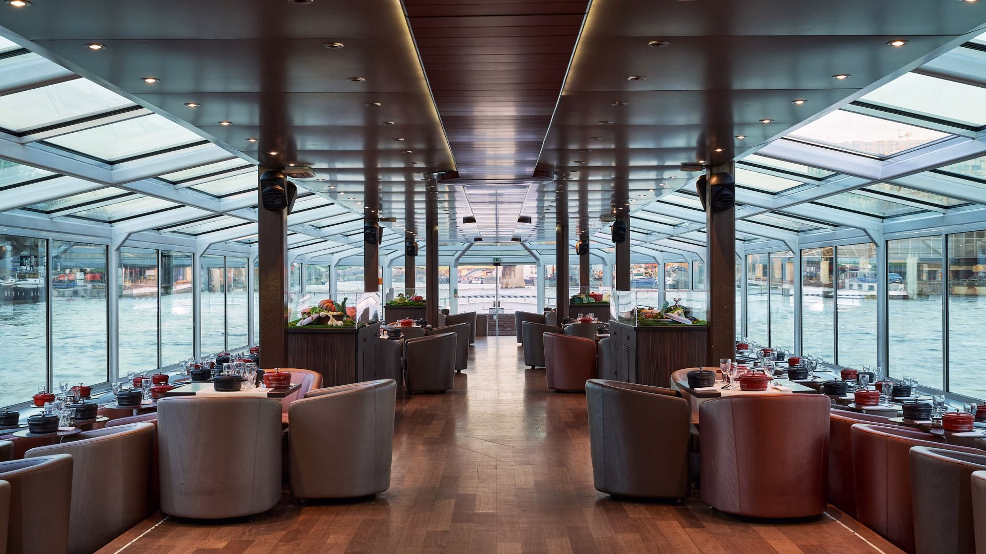 Salle de restaurant panoramique avec vue sur l'eau lors d'un diner croisière élégant sur la Seine | Paris en Scène