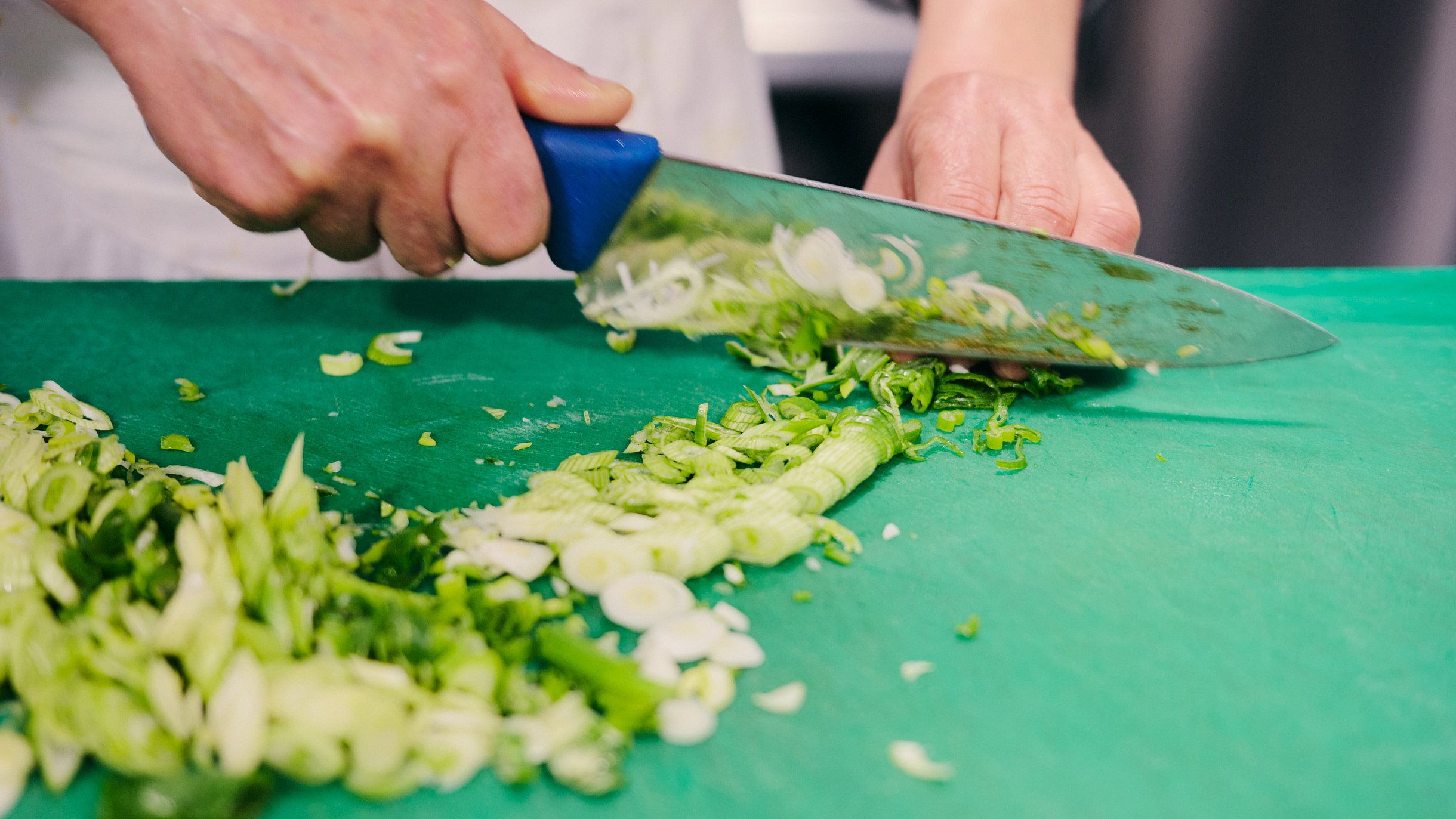 Découpe professionnelle d'échalotes en cuisine pour diner croisière d'exception sur la Seine | Paris en Scène