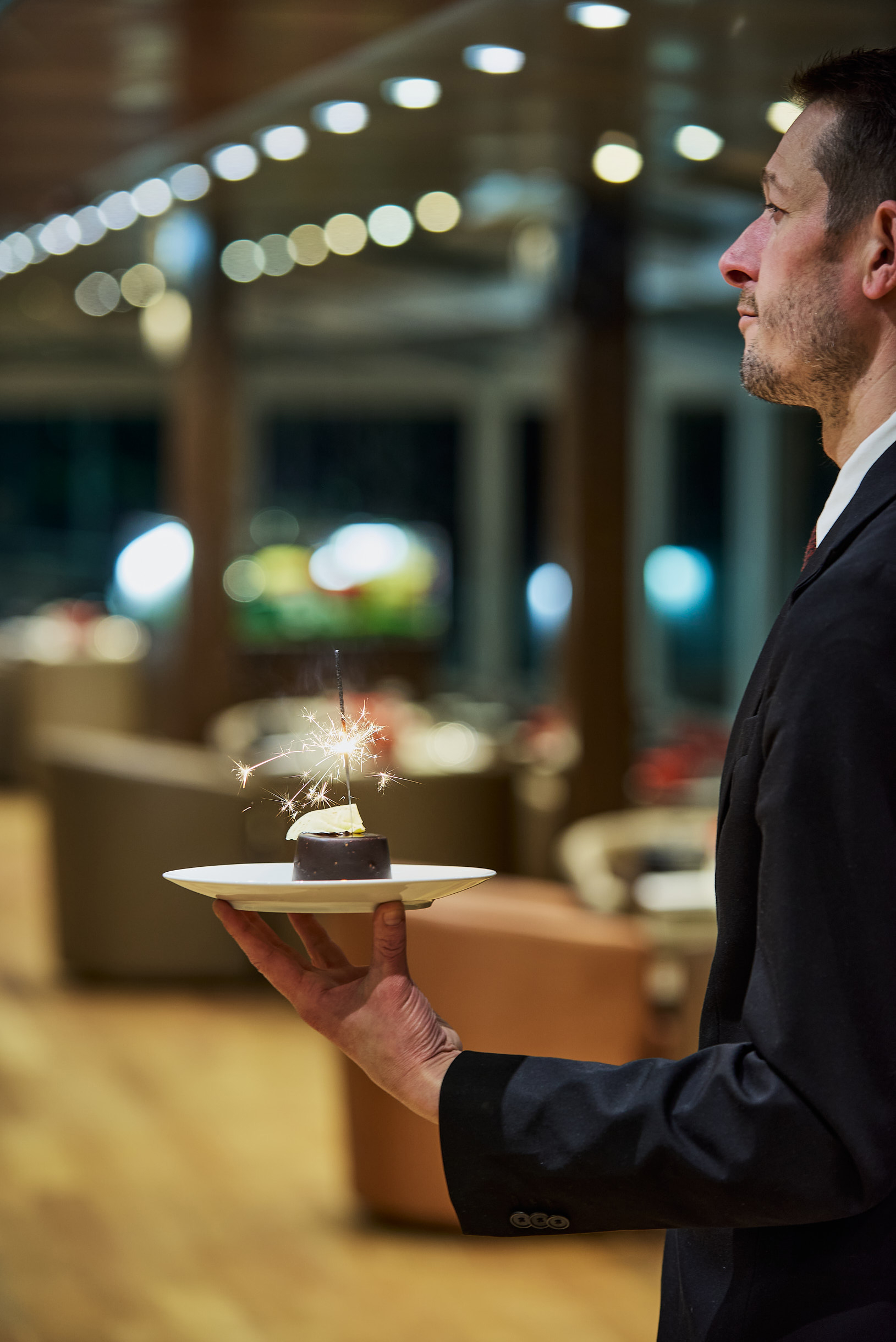 Dessert gourmand avec bougies magiques servi lors d'un anniversaire d'un dîner croisière sur la Seine à Paris, créant une ambiance festive et élégante | Paris en Scène