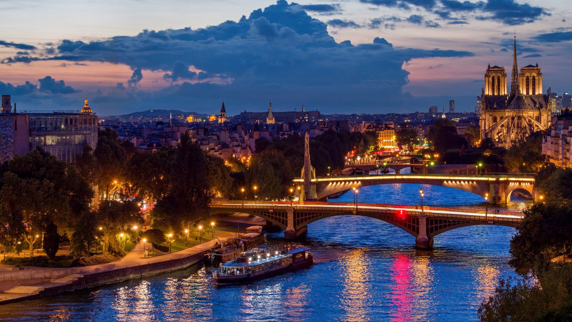 Vue panoramique de Paris au crépuscule, avec la Seine et Notre-Dame illuminées, idéale pour un dîner croisière offrant une expérience magique et romantique | Paris en Scène