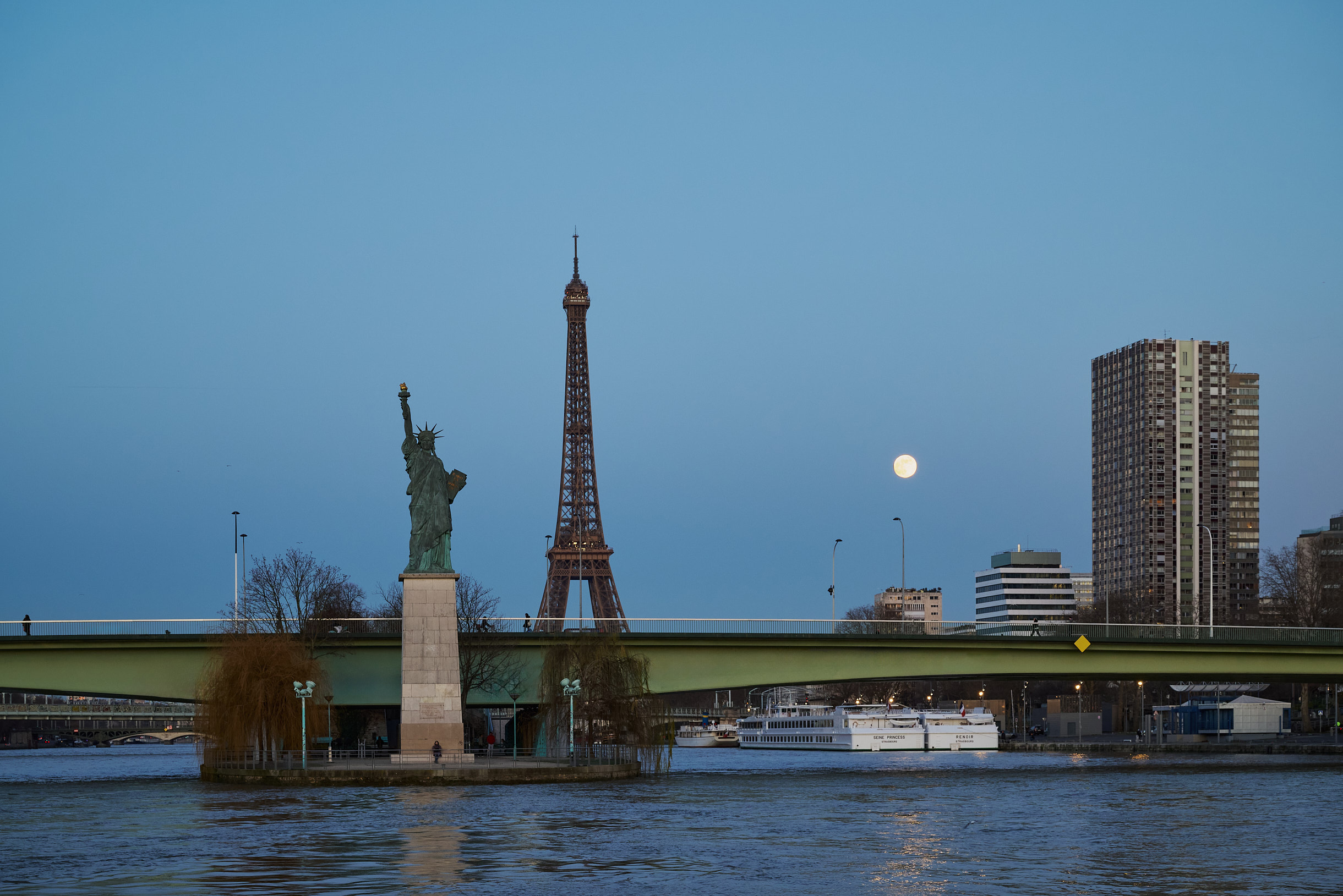 Statue de la Liberté parisienne et Tour Eiffel sous la lune lors d'un diner croisière romantique sur la Seine | Paris en Scène