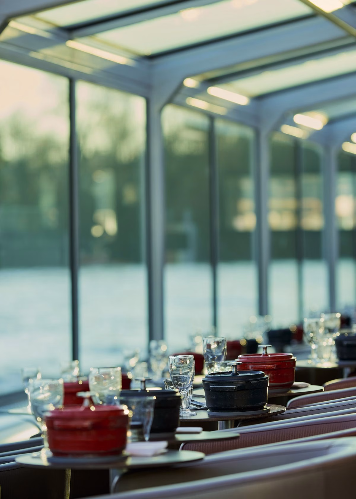 Ambiance lumineuse avec cocotte et verrerie fine pendant un diner croisière raffiné sur la Seine | Paris en Scène