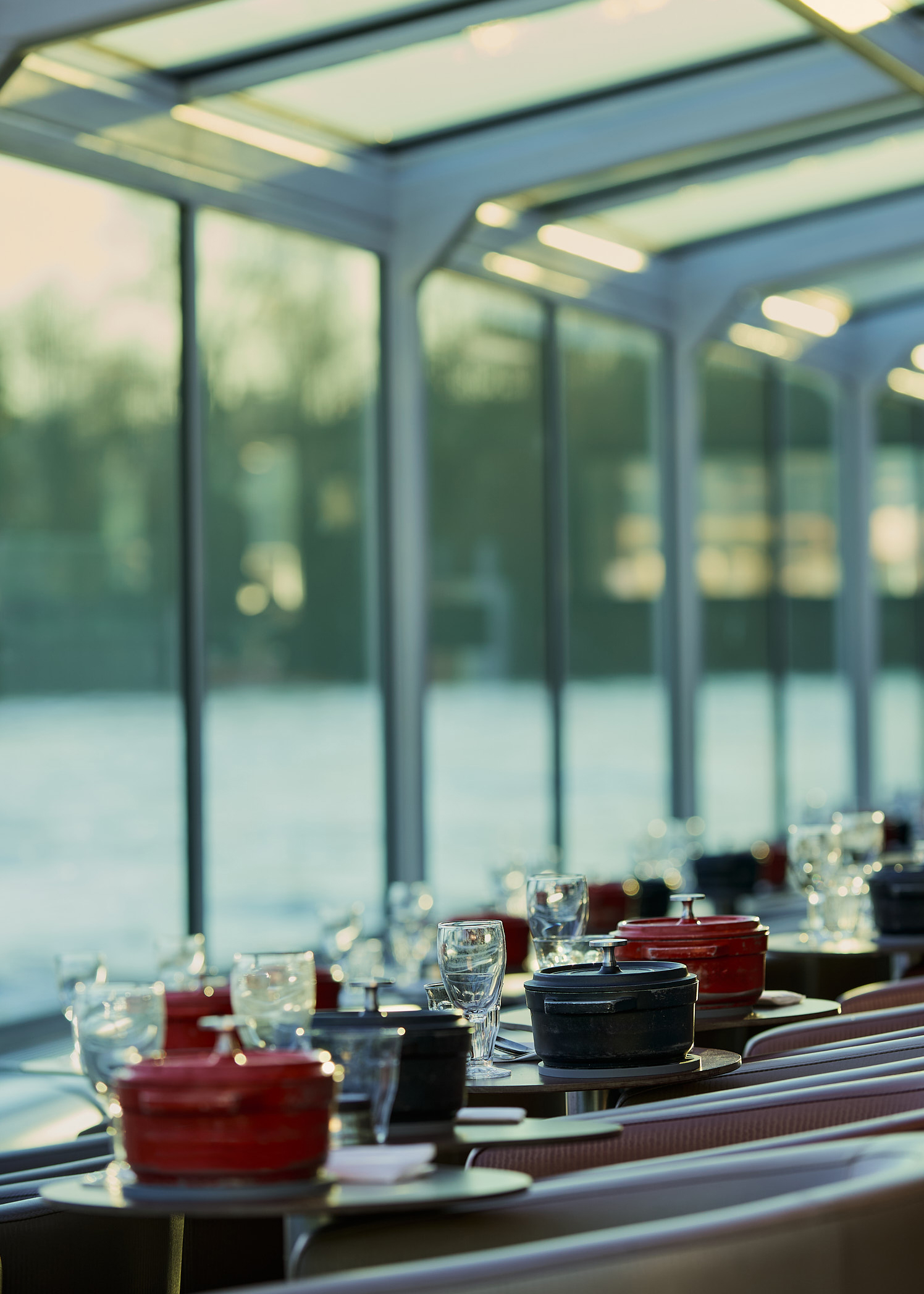 Ambiance lumineuse avec cocotte et verrerie fine pendant un diner croisière raffiné sur la Seine | Paris en Scène